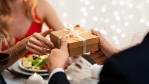 Romantic Couple Exchanging Gifts While Celebrating Valentine's Day In Restaurant